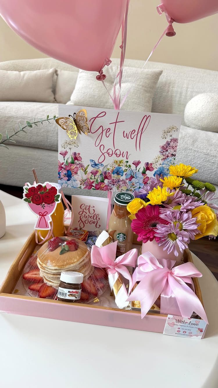 Get well soon gift tray with pancakes, fresh flowers, and pink balloons.