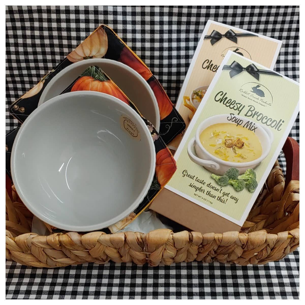 Woven gift basket with white soup bowls and cheesy broccoli soup mix package.