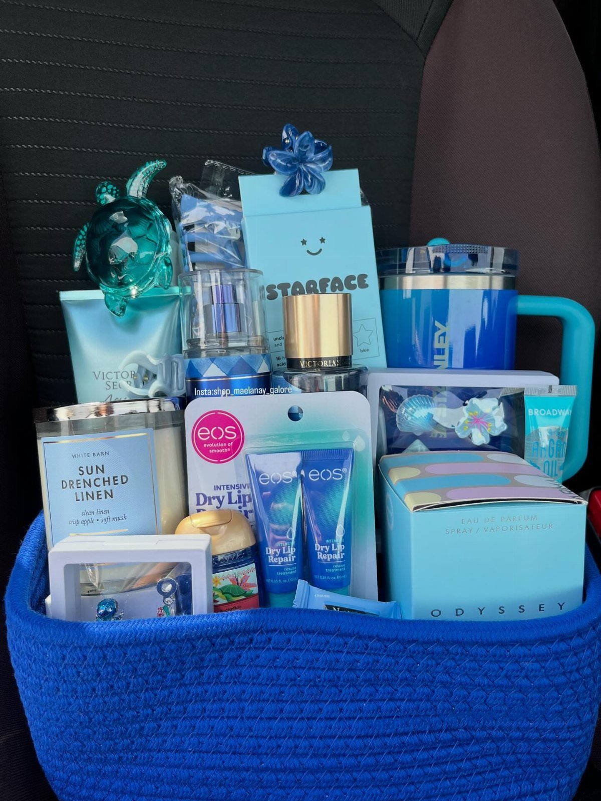 Blue woven gift basket filled with blue beauty products and a blue tumbler.