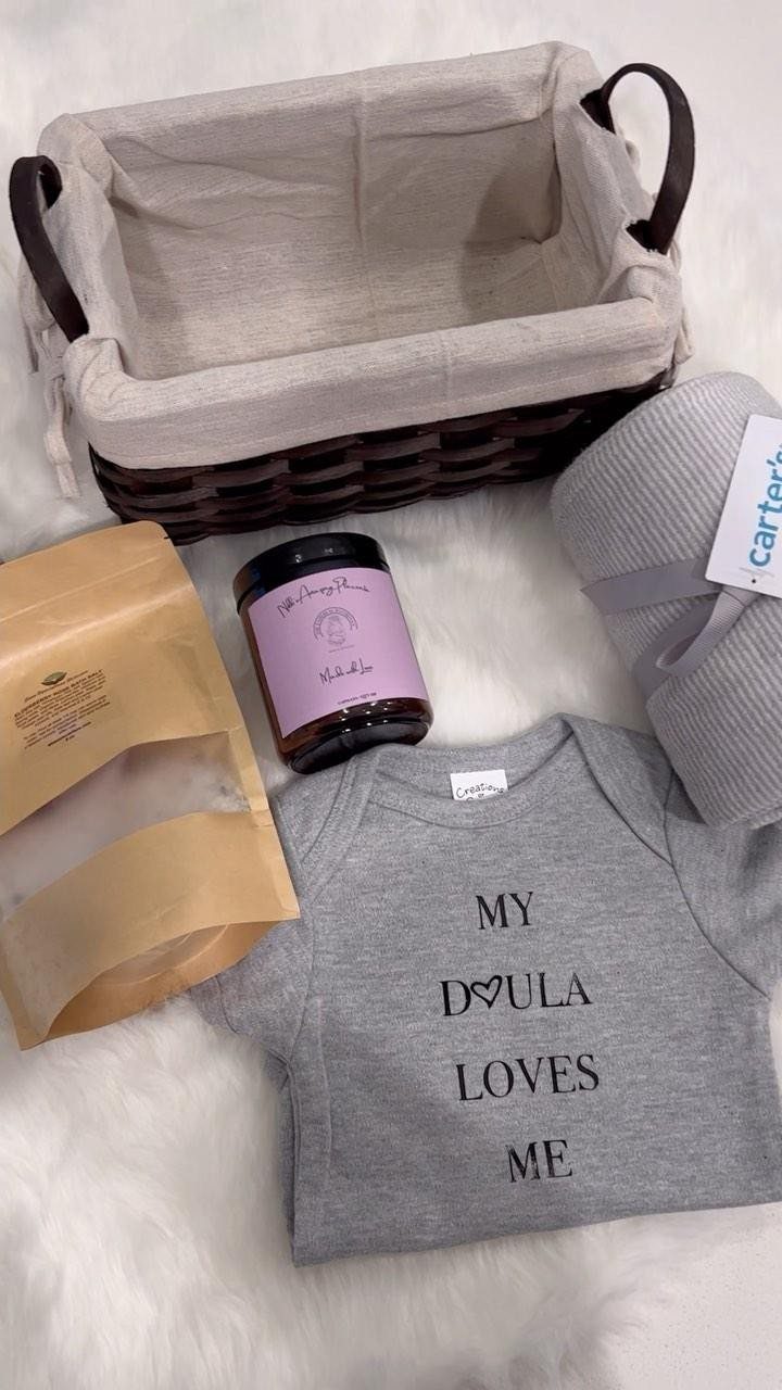 Postpartum gift basket items including a baby onesie, blanket, and care products.