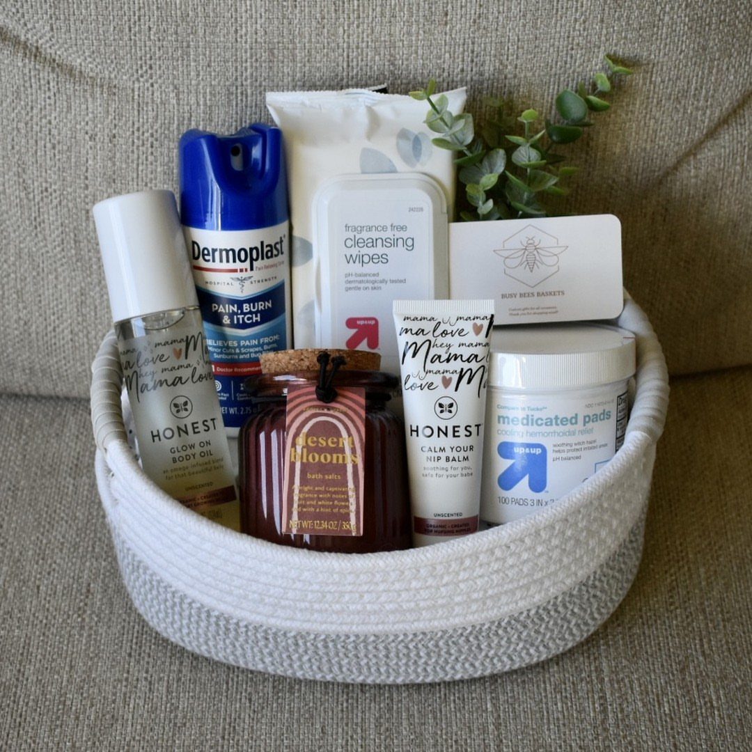 White woven basket filled with postpartum recovery products and a jar of honey.