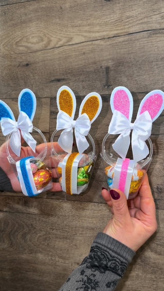Three plastic bottle Easter baskets with glittery bunny ears and colorful candy eggs.