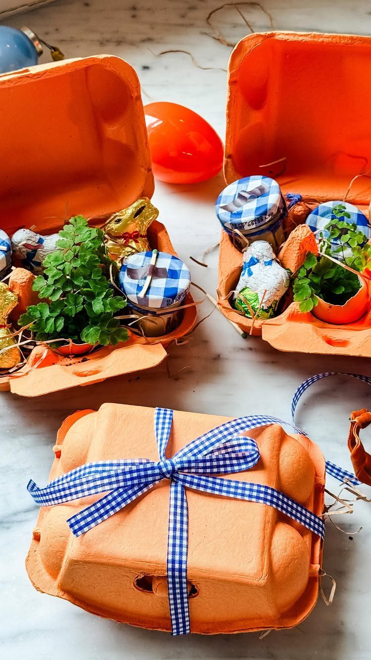 Orange egg cartons repurposed as Easter baskets filled with plants and treats.