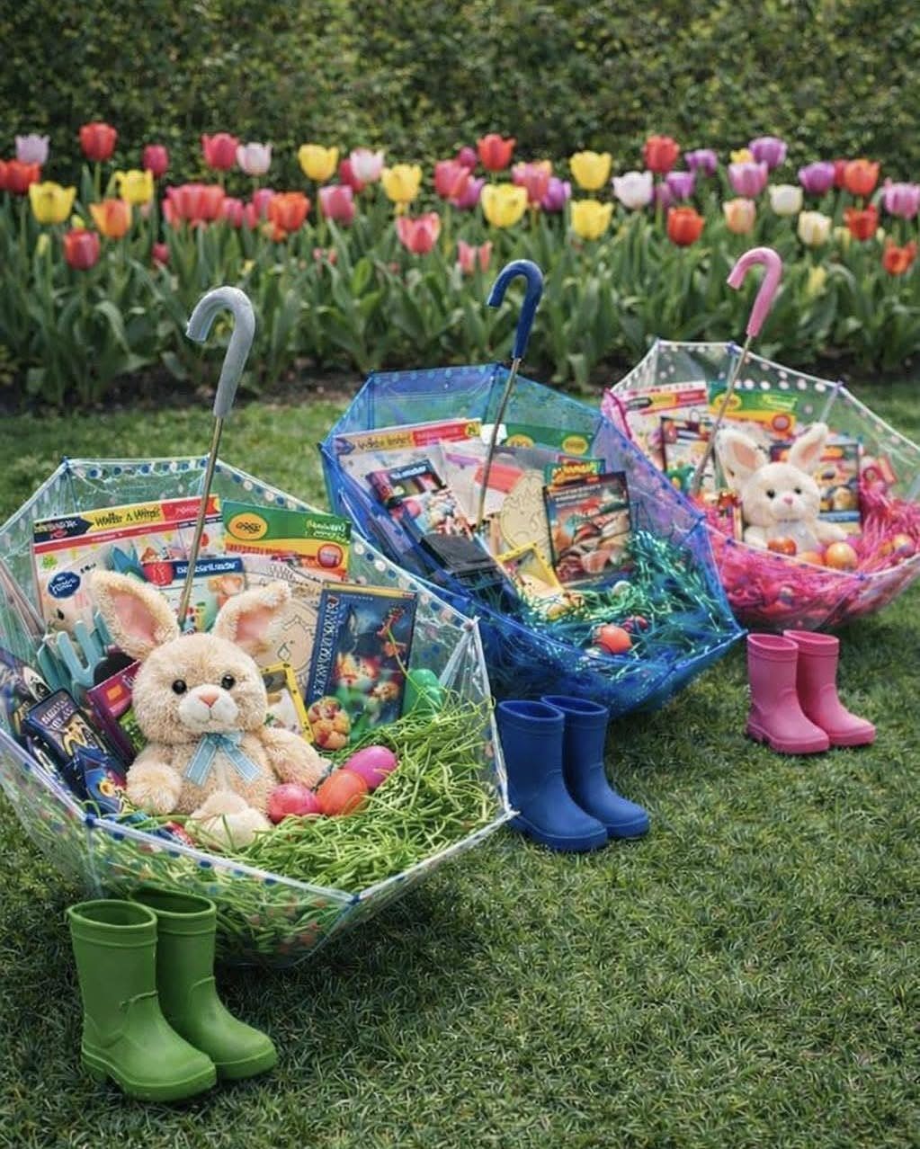 Three umbrella-shaped Easter baskets with plush bunnies and boots on a grassy lawn