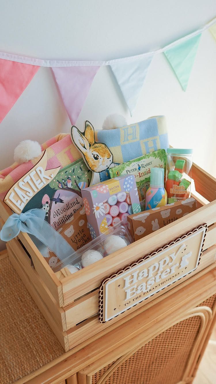 Wooden Easter gift crate filled with books, treats, and pastel decorations.