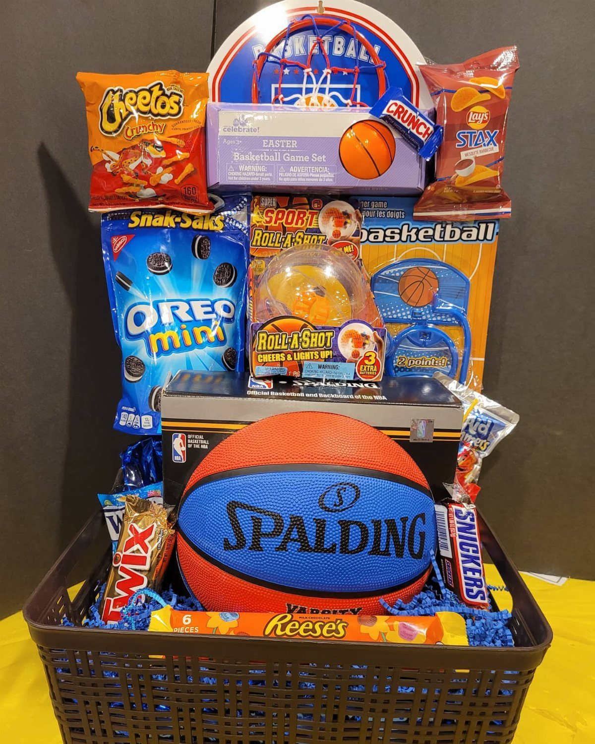 Brown basket filled with snacks and basketball gear for an Easter gift.