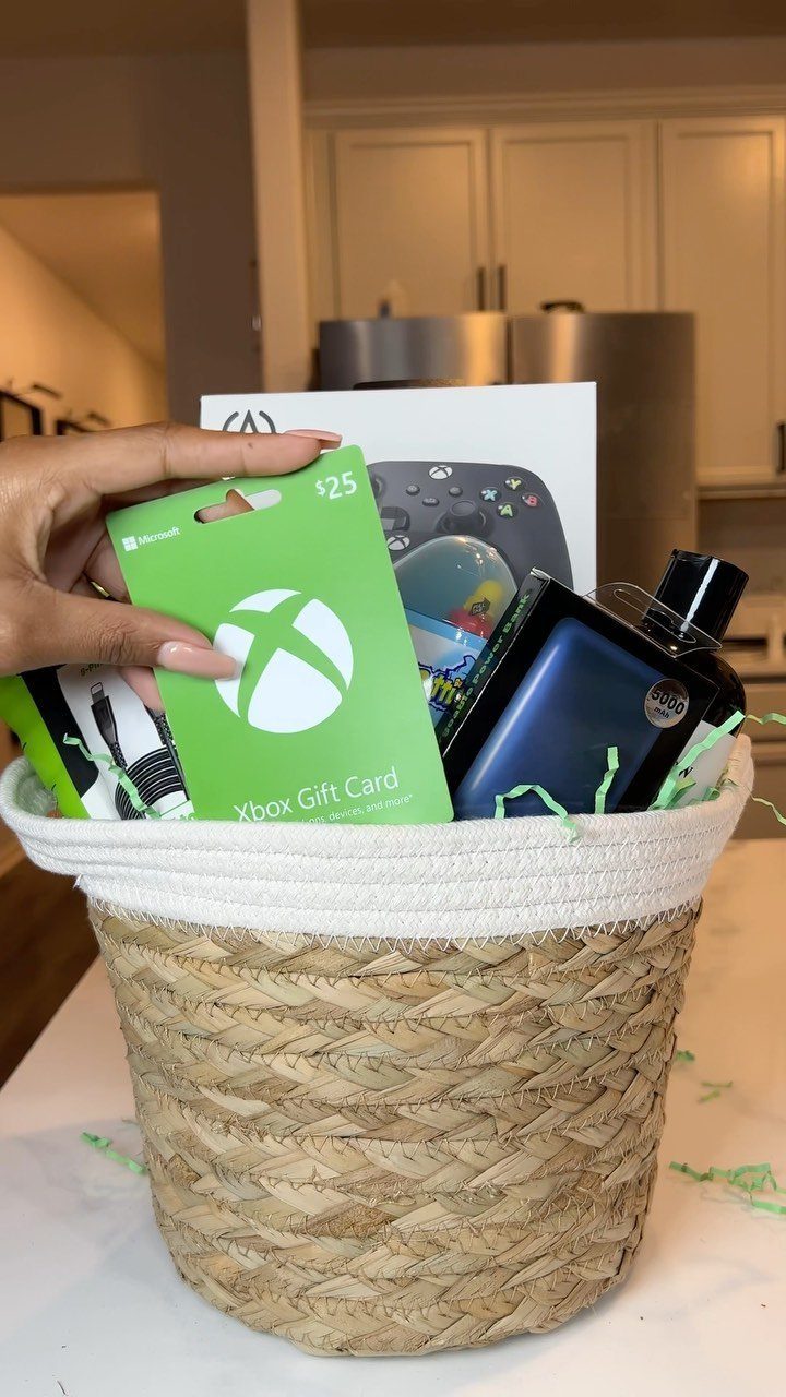 Woven wicker basket filled with a blue cologne bottle and Xbox gift card.