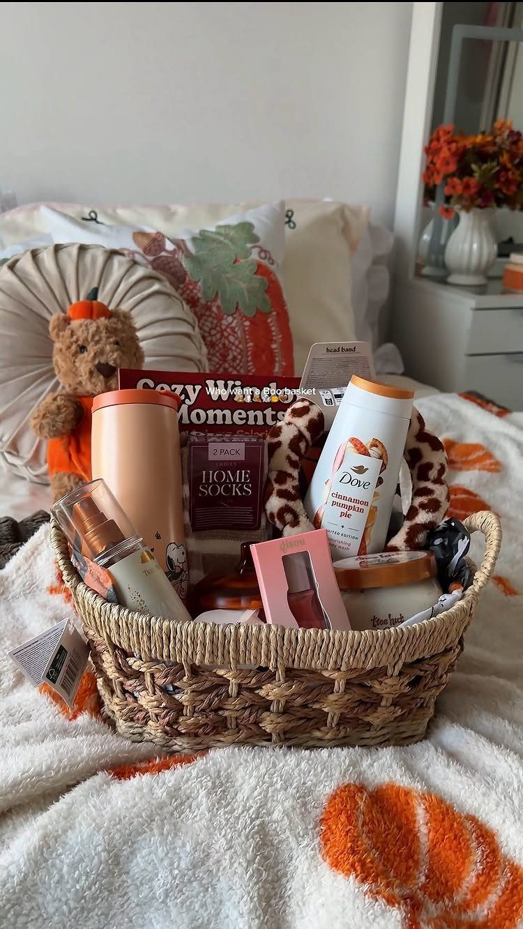 Woven gift basket with lotion, candle, and teddy bear on a cozy blanket.
