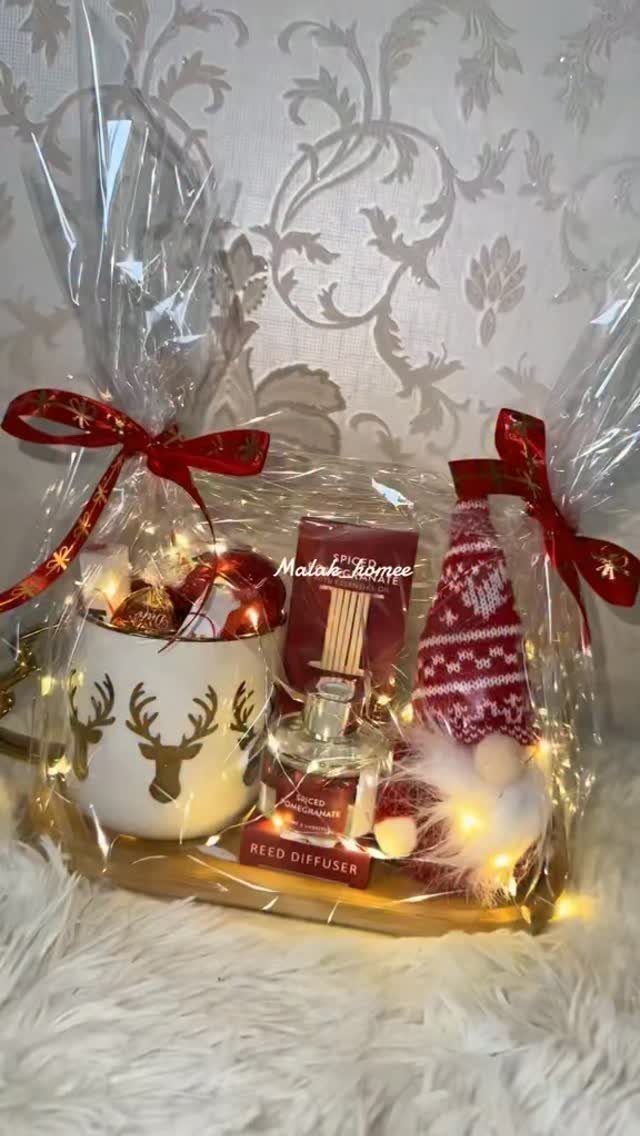 Christmas gift basket with reindeer mug, reed diffuser, and Santa hat in cellophane