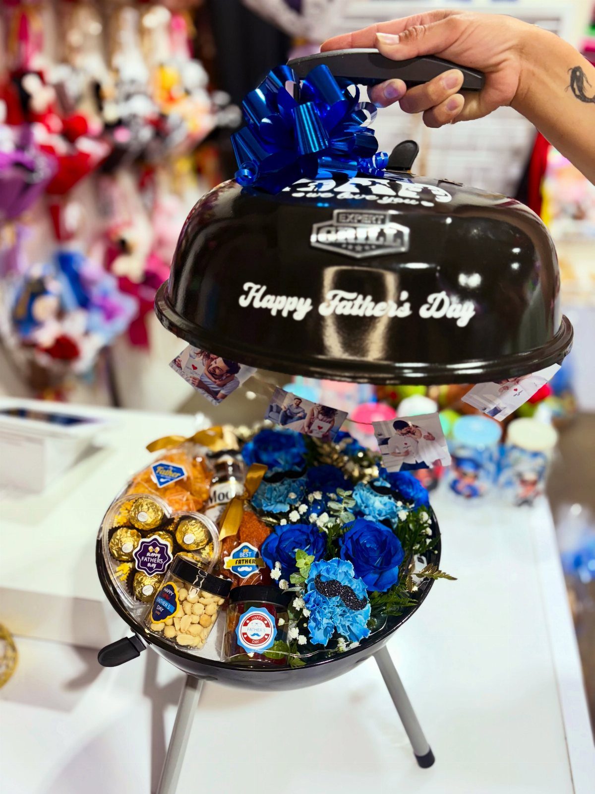 Black charcoal grill gift basket filled with snacks and blue flowers for Father's Day