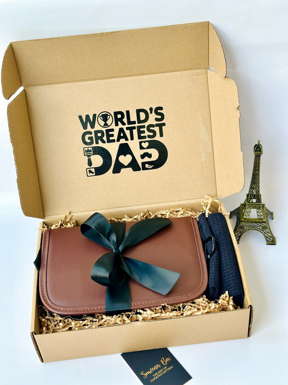 Brown gift box for dad containing a leather pouch and Eiffel Tower model.