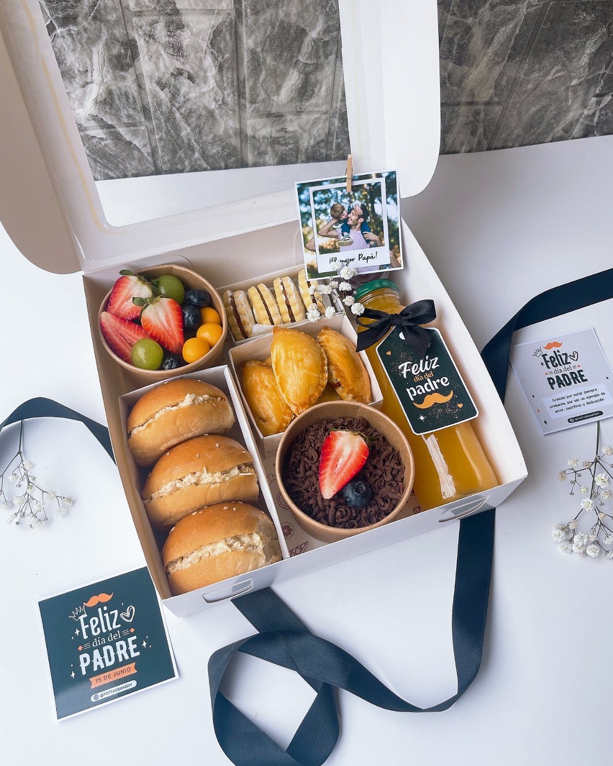 Gourmet food gift box with sandwiches, pastries, fruit, juice, and Father's Day cards.
