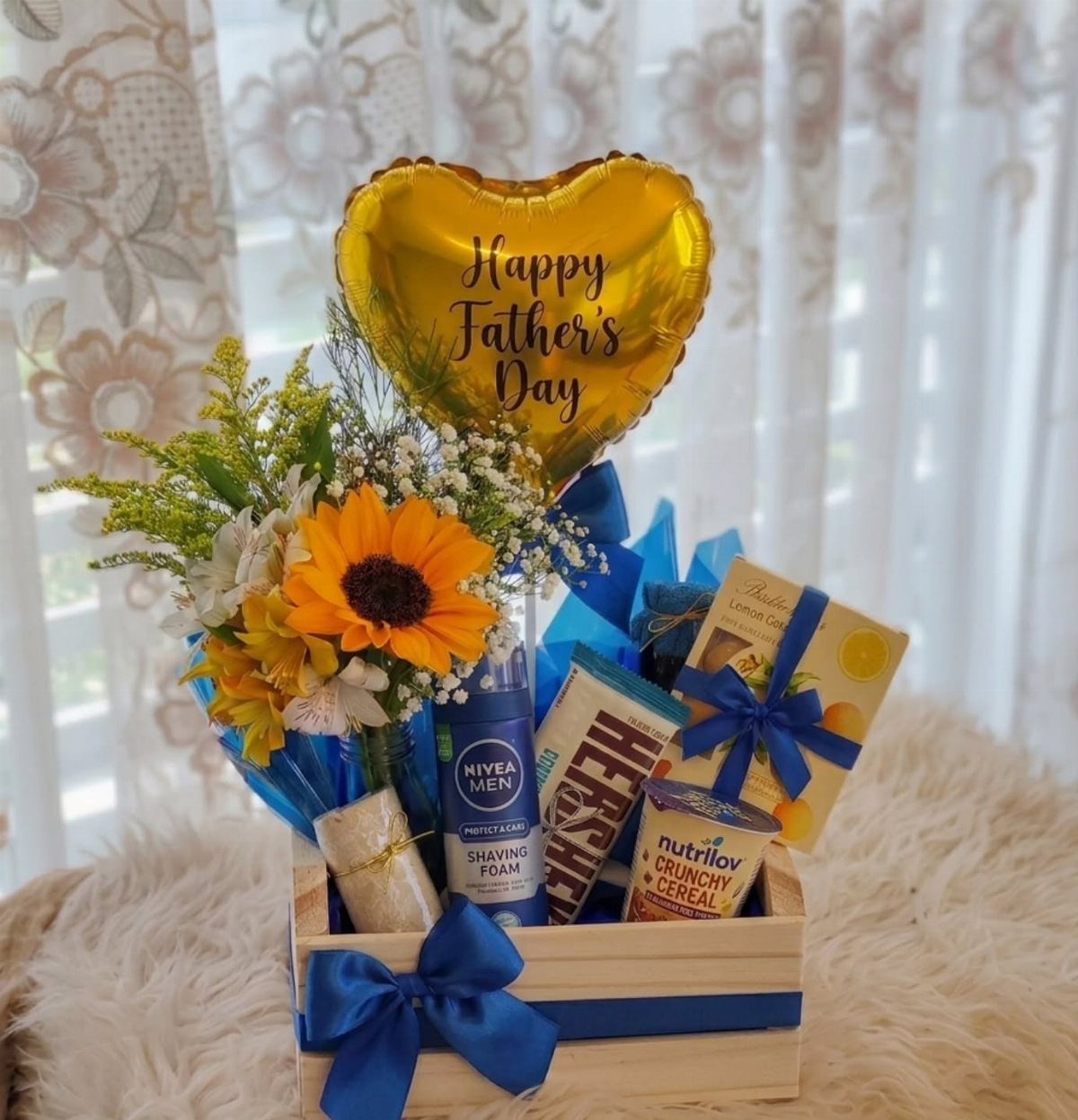 Wooden gift crate with sunflower bouquet, gold heart balloon, and grooming products.