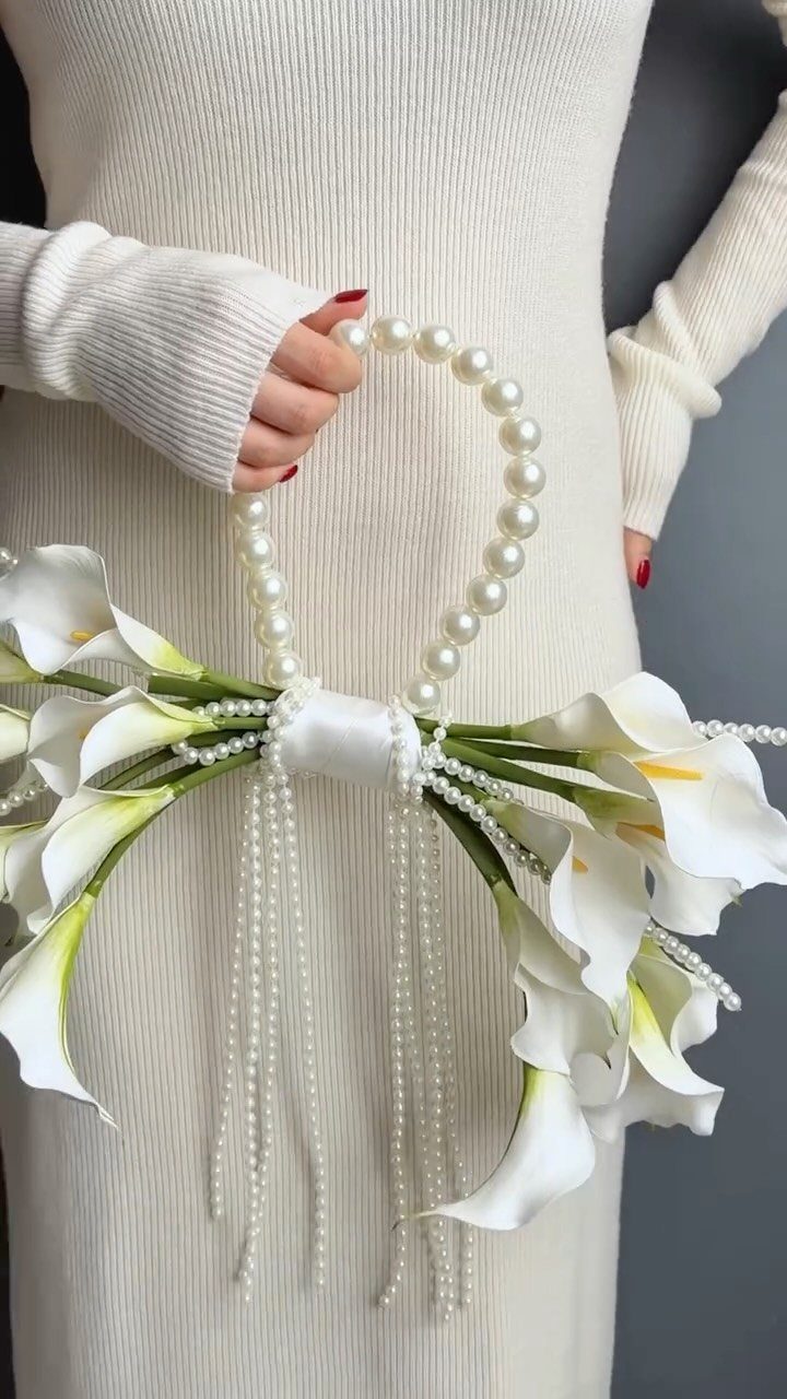 White calla lily bouquet with pearl handle and cascading beads held by woman