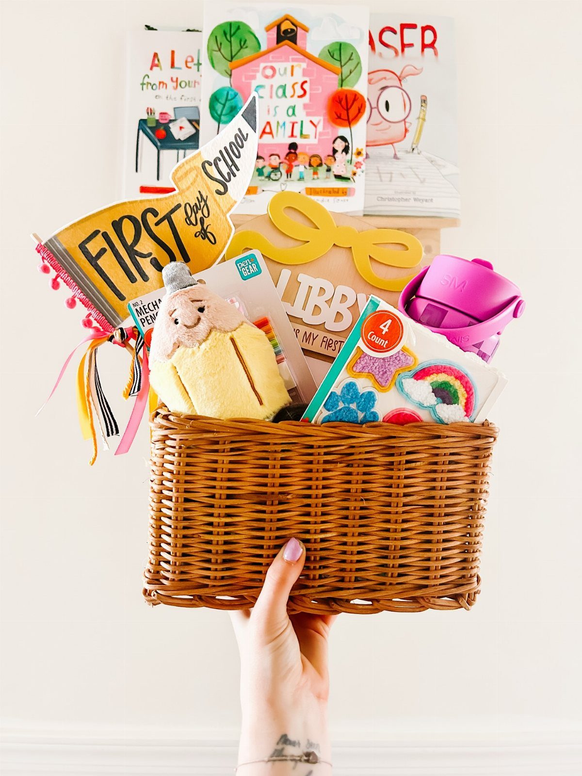 Wicker basket filled with children's books and school supplies for the first day.