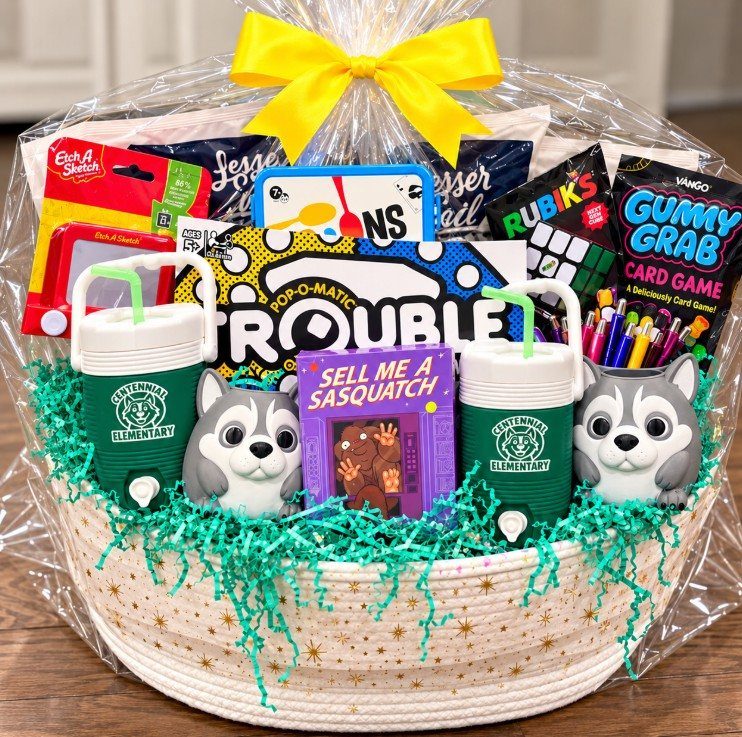 Game night gift basket with board games, green tumblers, and husky figurines in cellophane.