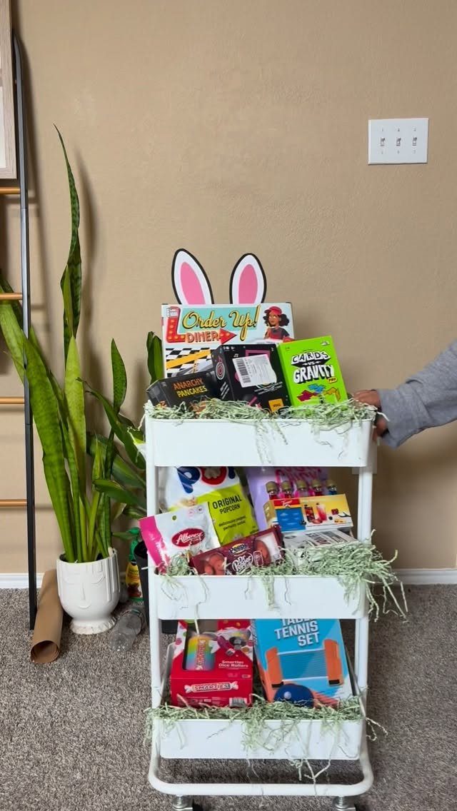 White rolling cart filled with board games and snacks as a raffle prize.