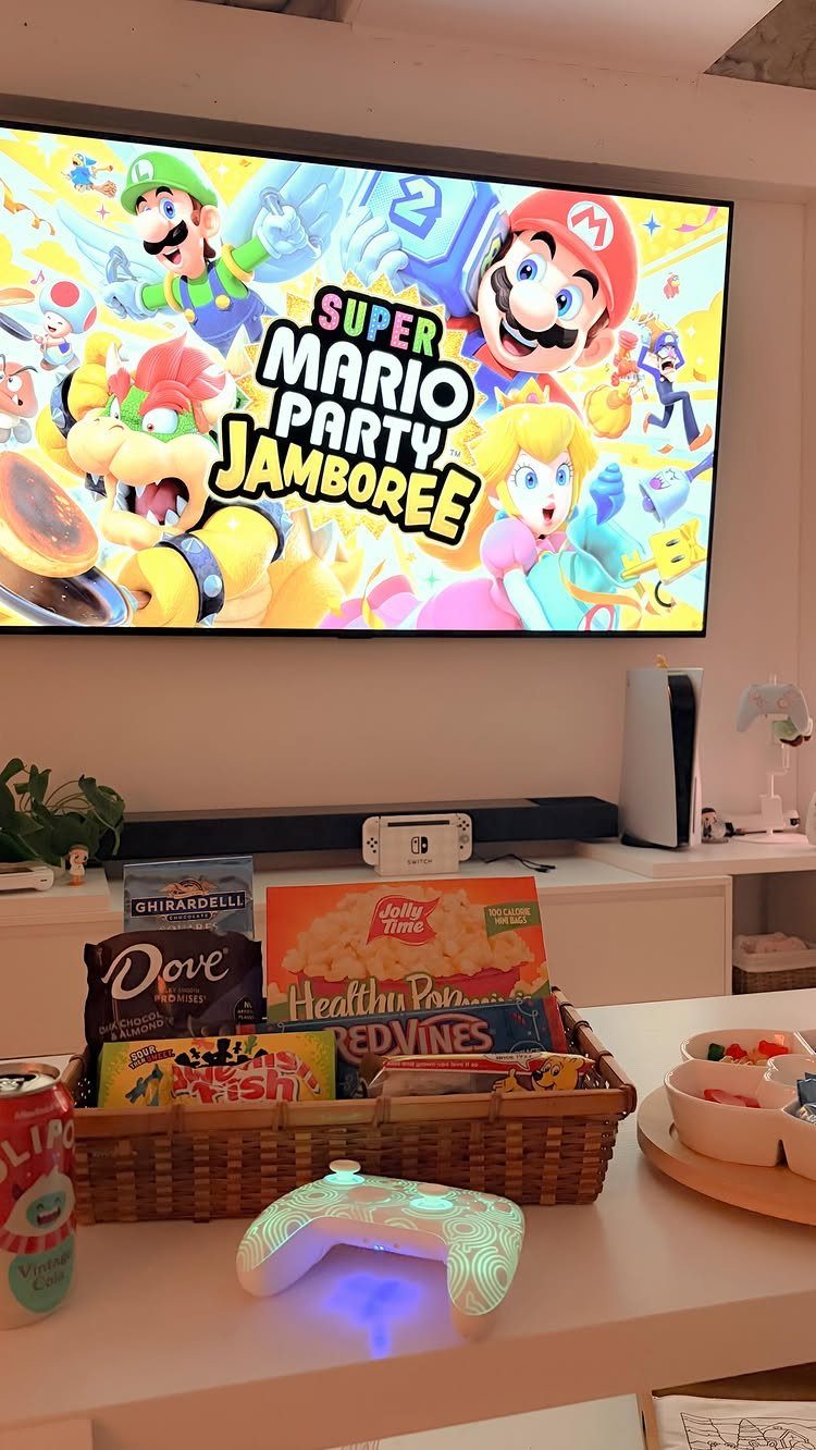 Wicker basket of snacks and a game controller before a Mario Party screen.