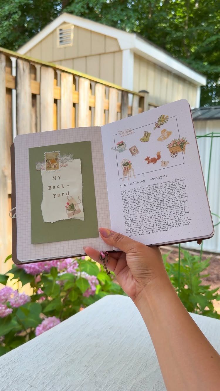 Open garden journal with sketches and notes held against a backyard background.