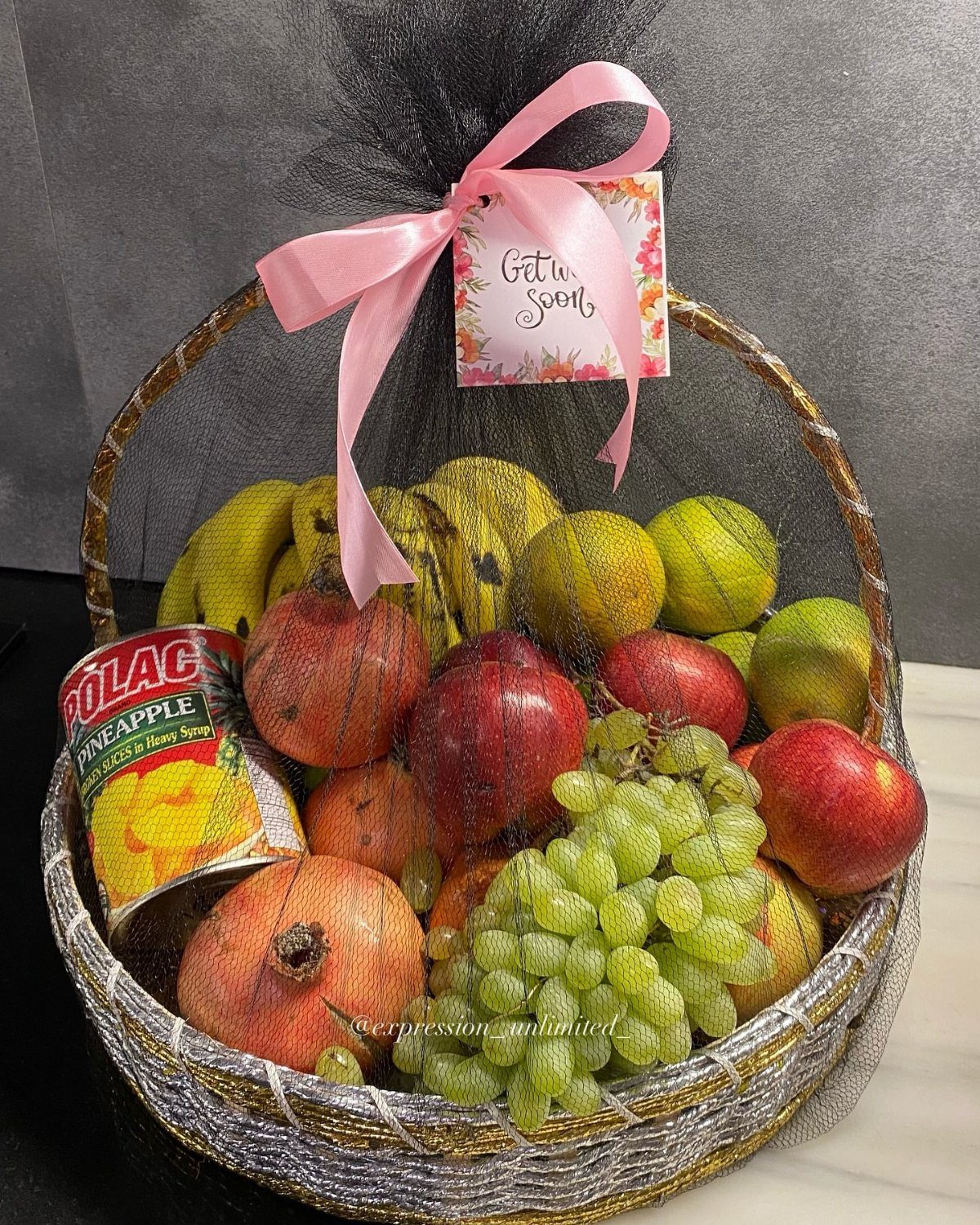 Fruit gift basket with grapes, apples, and bananas featuring a Get Well Soon card