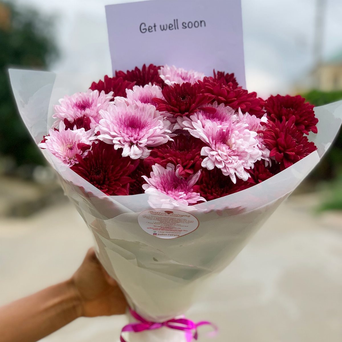 Bouquet of pink and red chrysanthemums with a get well soon card