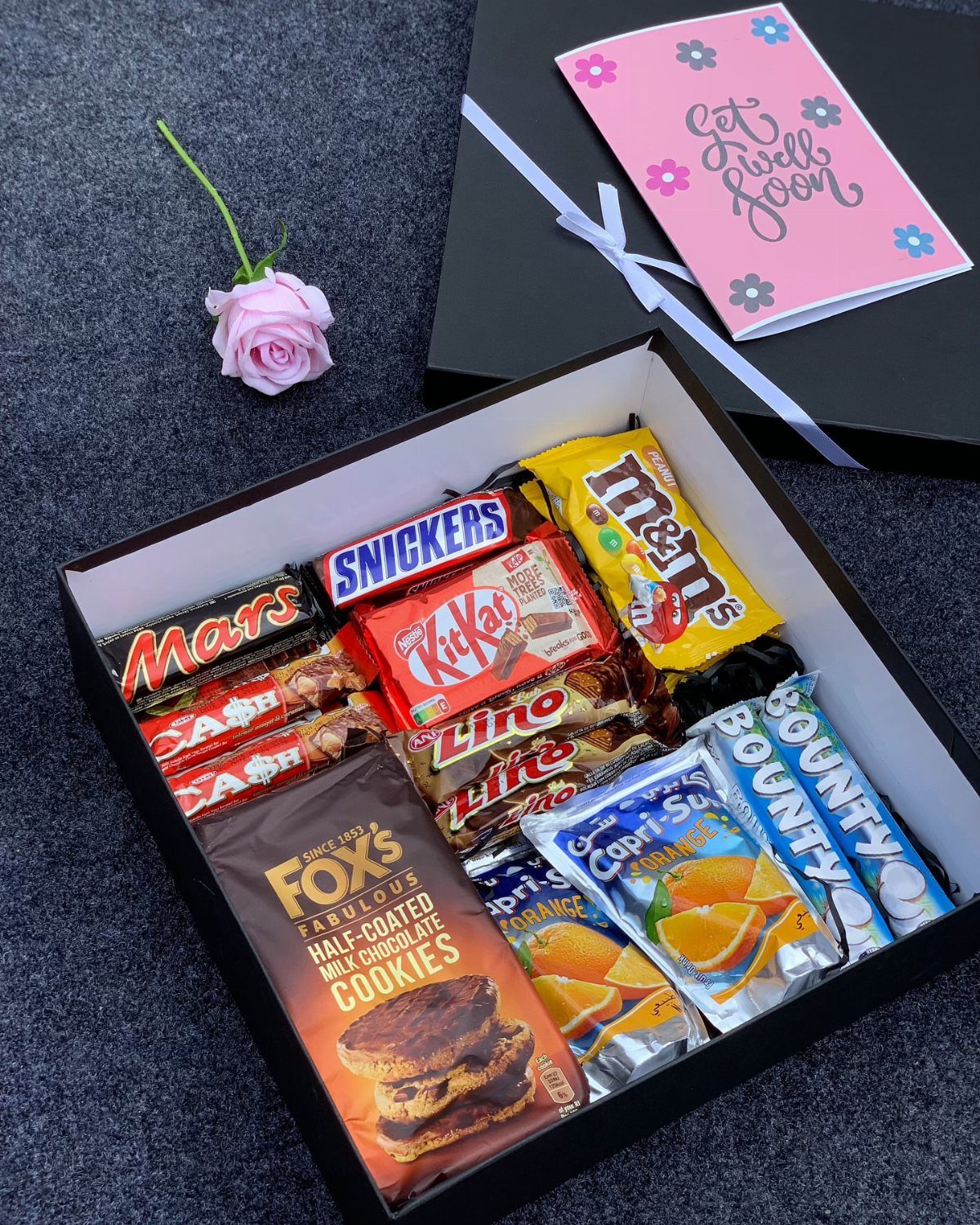 Chocolate gift box with a pink get well soon card and rose.