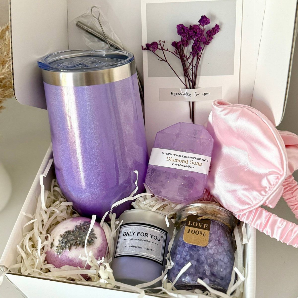 Purple themed spa gift set with tumbler, bath salts, candle, and sleep mask.