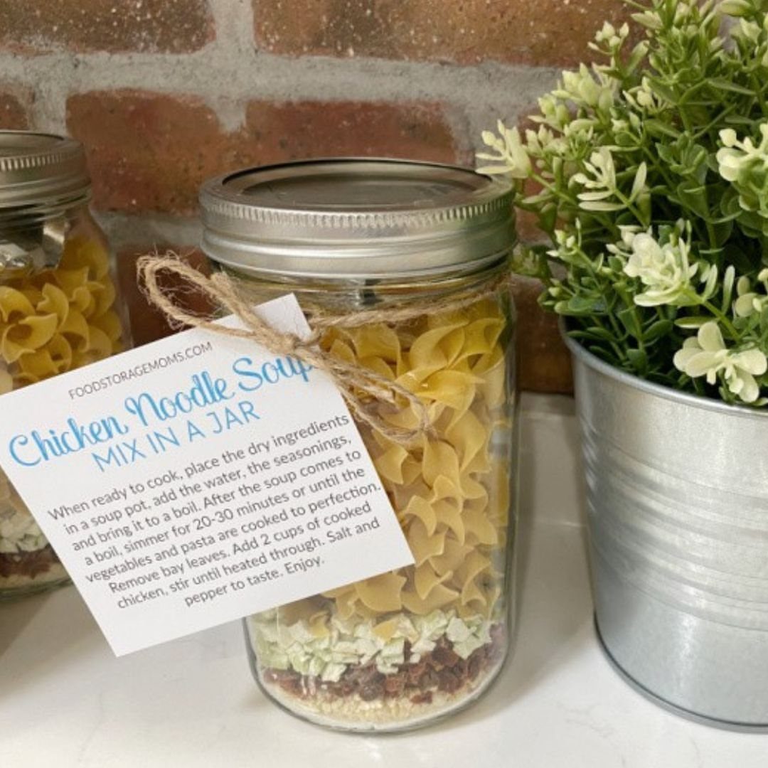 Mason jar filled with layered chicken noodle soup mix and instruction tag.