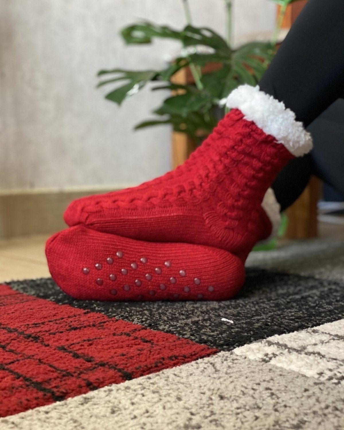 Red cable-knit crew socks with white fluffy trim and non-slip grips on soles.