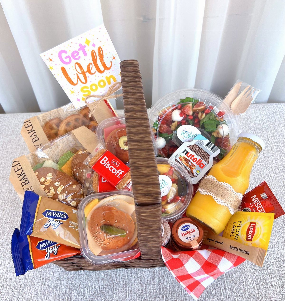 Gourmet breakfast basket with orange juice, pastries, and a Get Well Soon card.