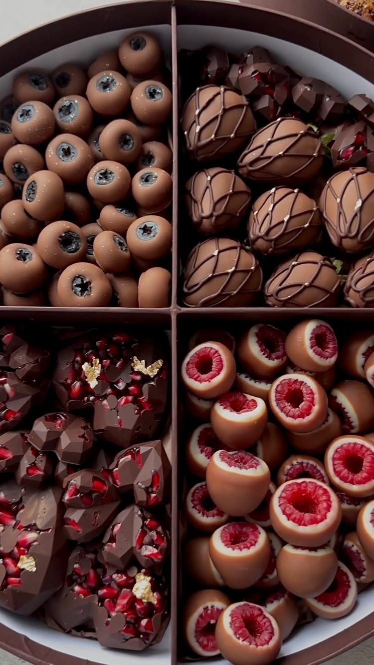 Gourmet chocolate gift box with fruit-filled chocolates and truffles in four sections.