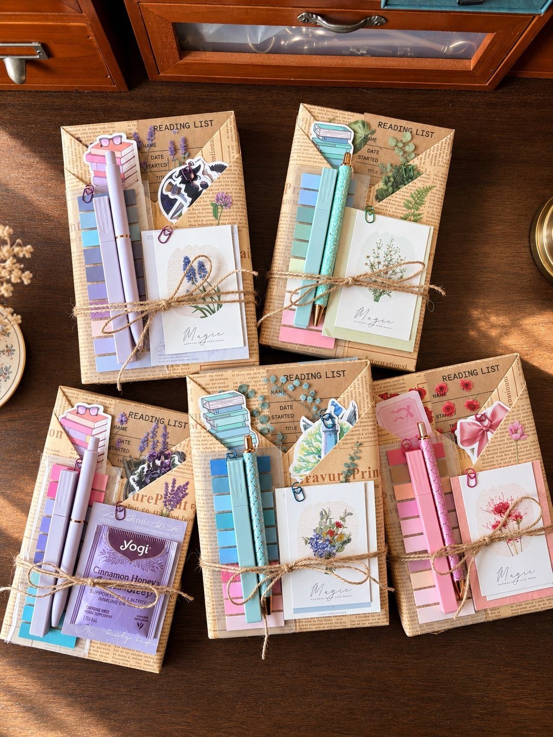 Handmade stationery kits with notebooks, pencils, and floral cards tied with twine.