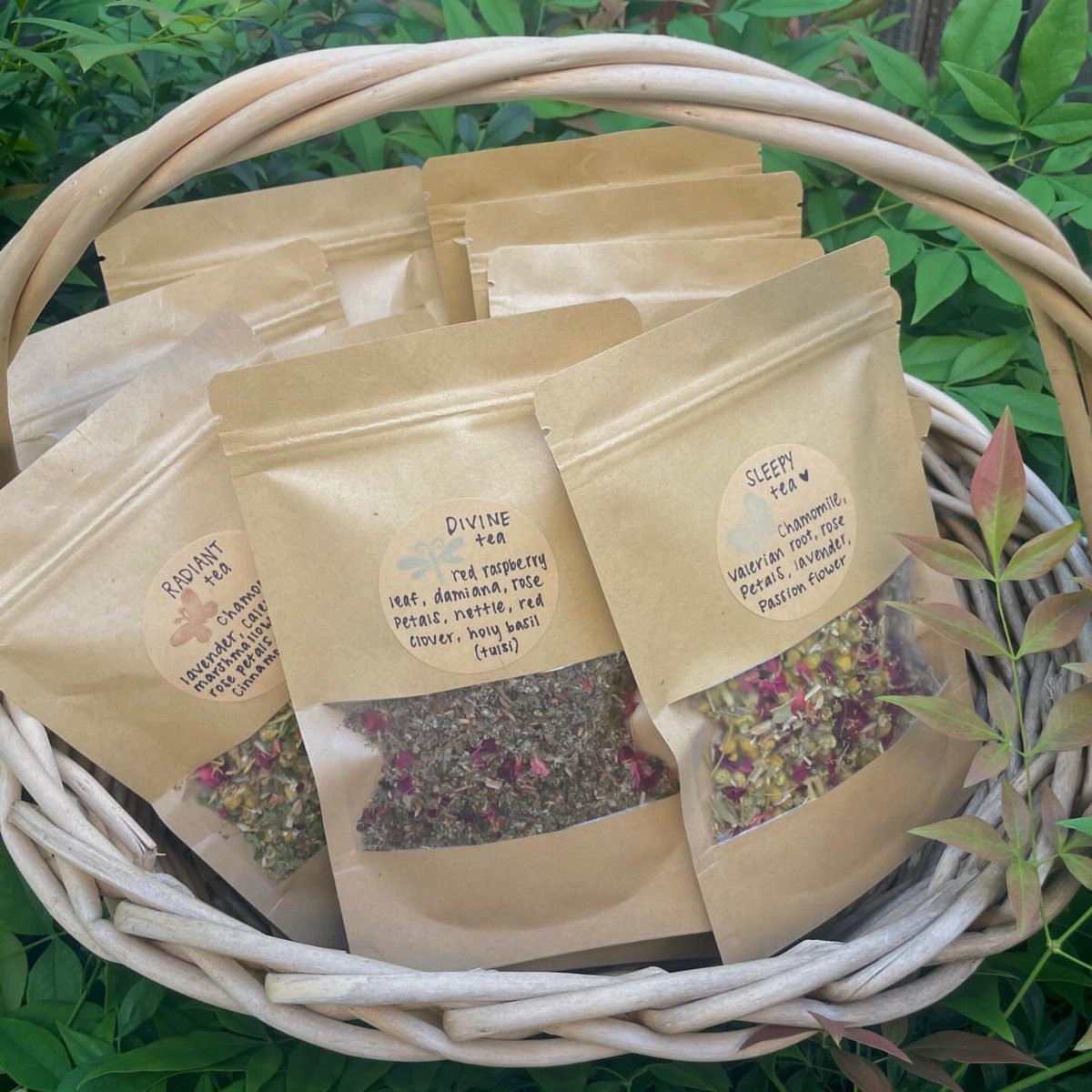 Herbal tea blends in brown paper pouches inside a woven wicker basket.