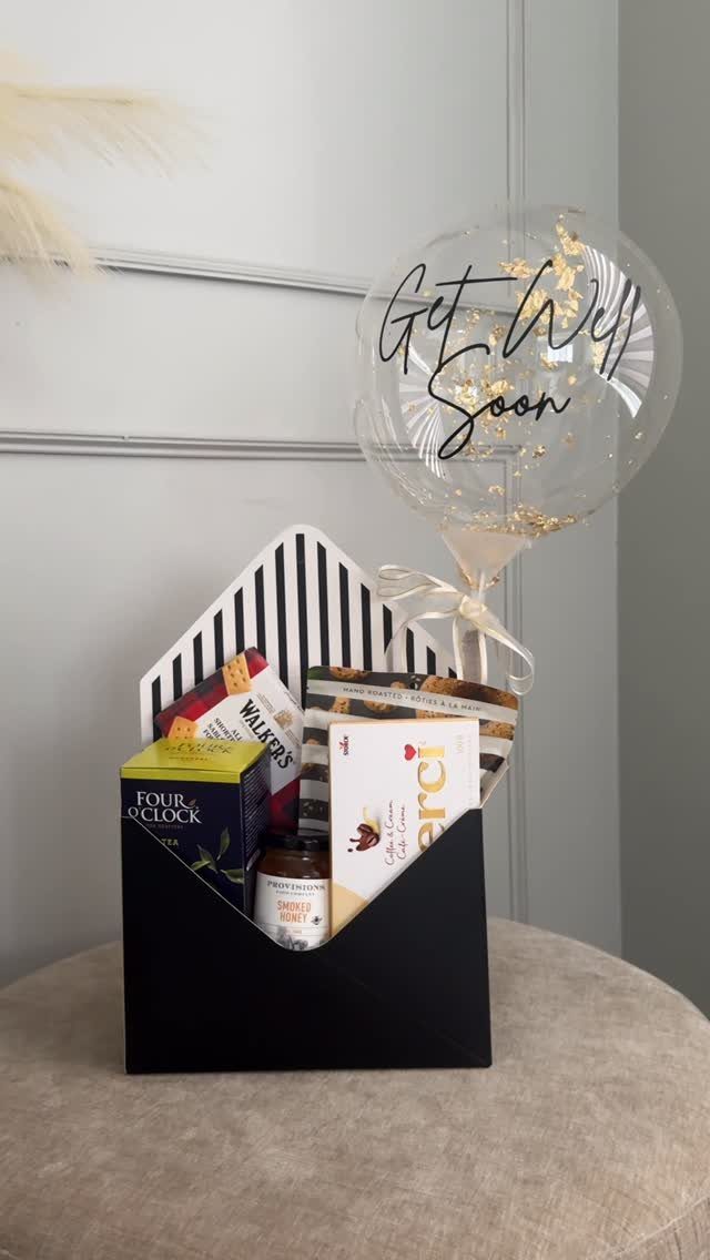 Get well soon gift package with snacks and a clear confetti balloon.