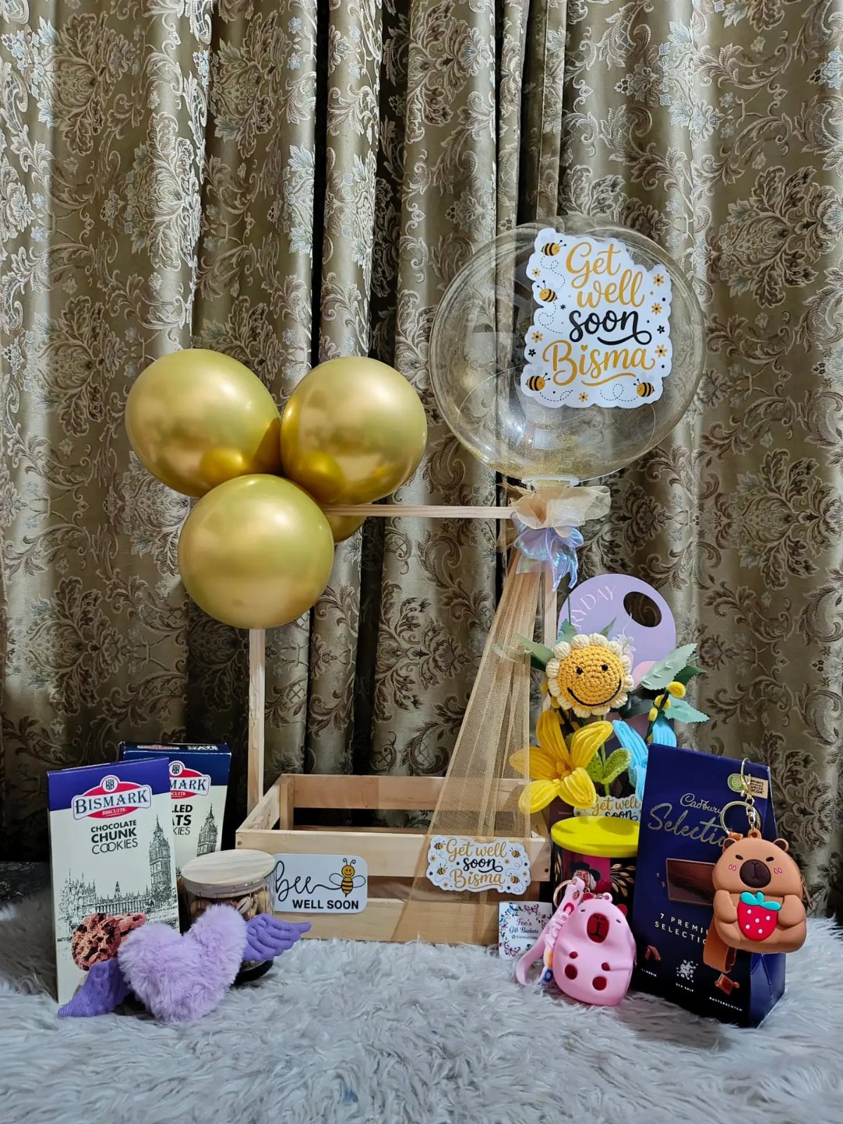 Get well soon gift hamper with gold balloons, chocolates, and a personalized balloon.