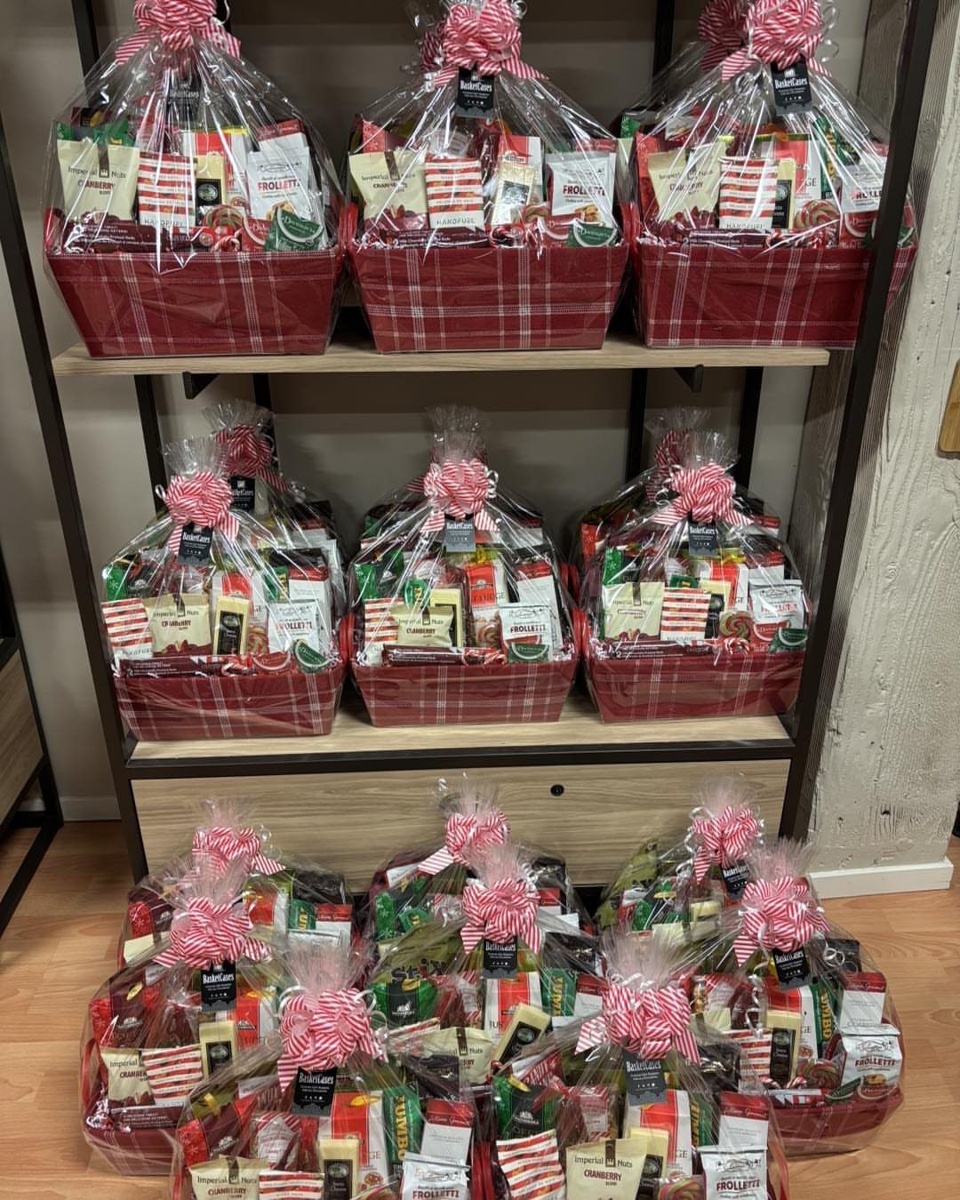 Red plaid gift baskets filled with treats, wrapped in cellophane with striped bows.
