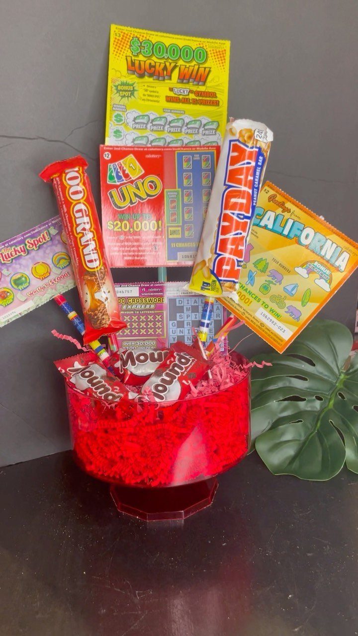 Red gift basket filled with lottery tickets, Uno cards, and candy for auction.
