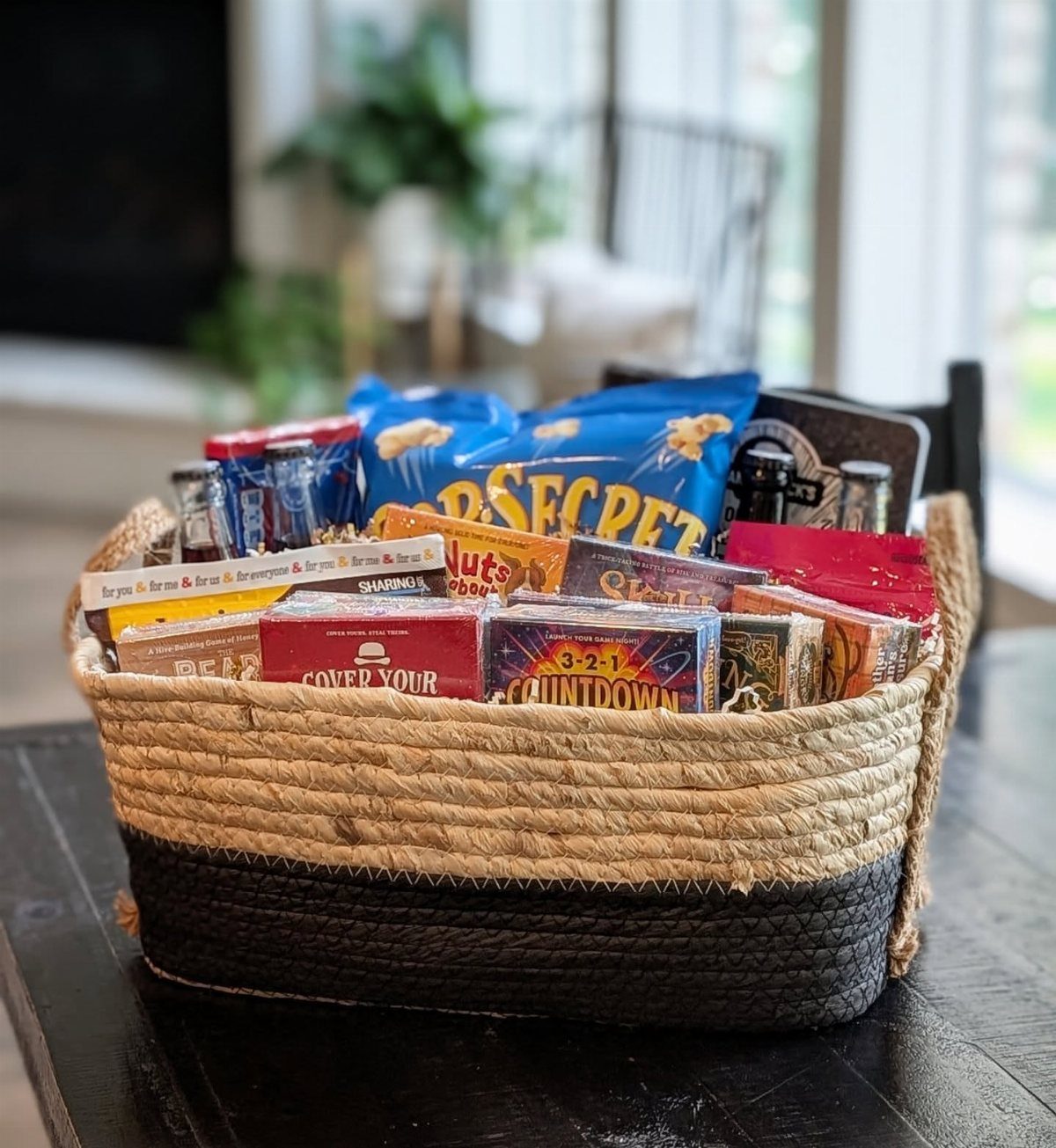 Woven straw basket filled with assorted packaged snacks and candies on a table