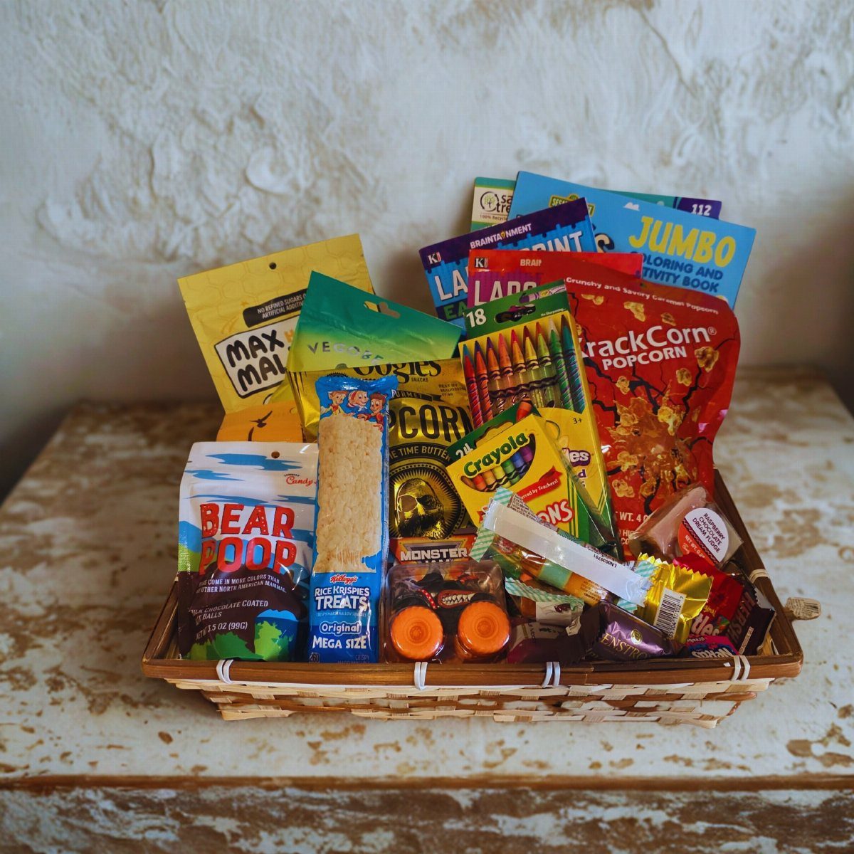 Woven gift basket filled with colorful snacks, crayons, and a coloring activity book.