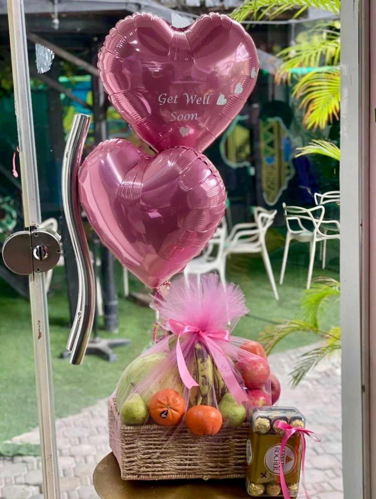 Fruit gift basket with pink heart balloons and Get Well Soon message