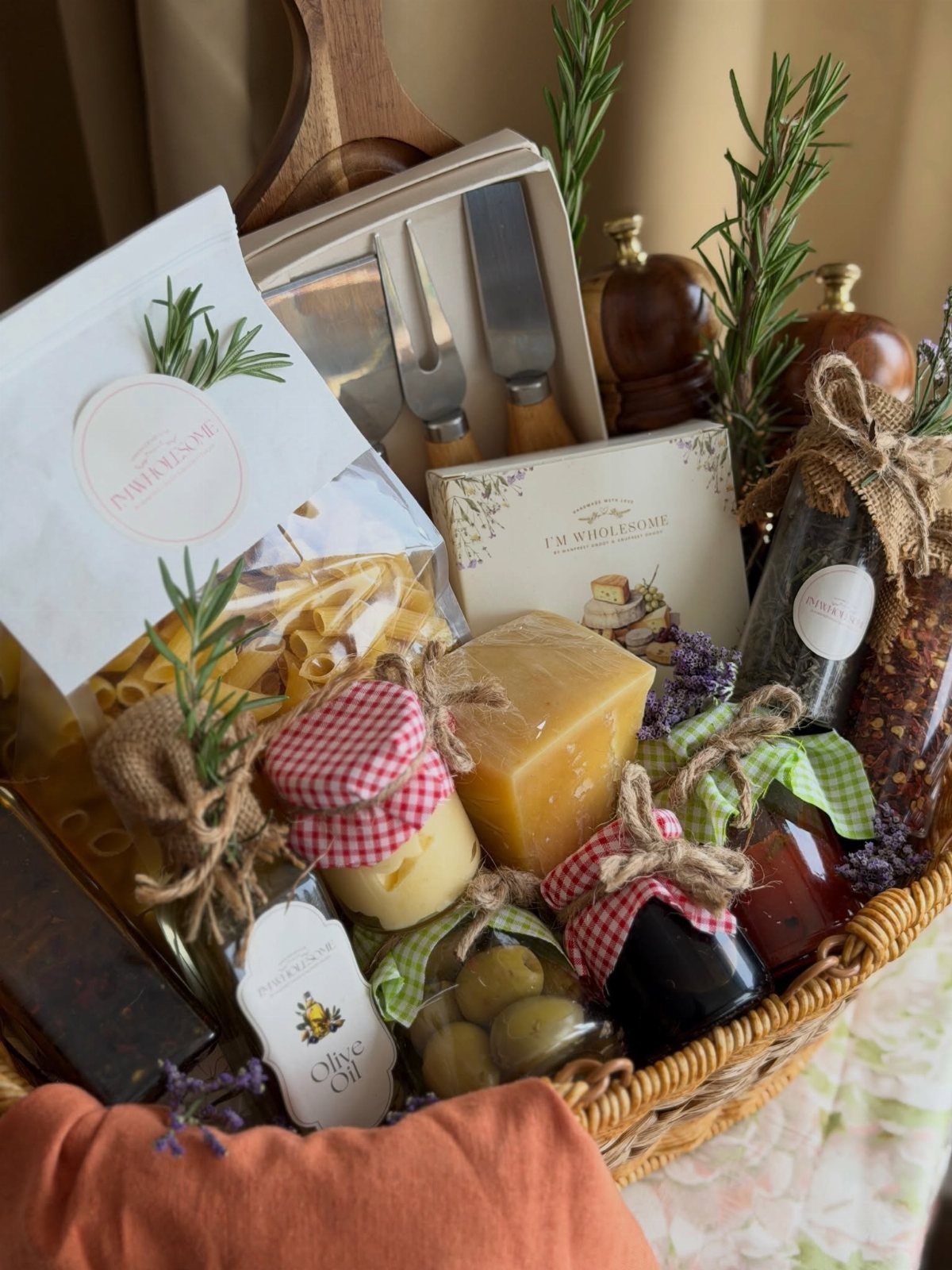 Wicker gift basket filled with pasta, cheese, gourmet jars, and cheese knives.