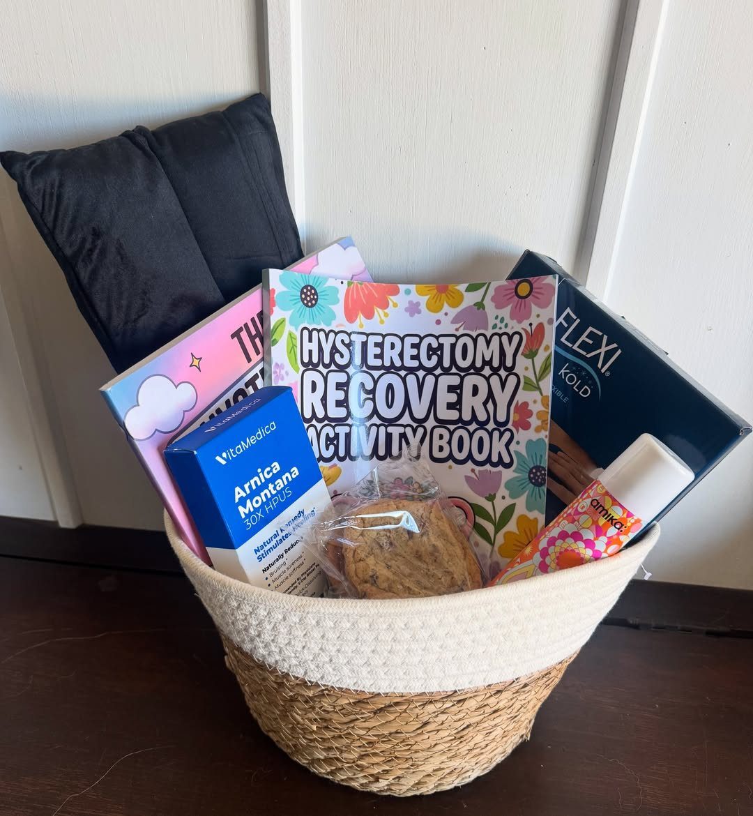 Recovery gift basket with a hysterectomy activity book, heating pad, and Arnica pellets.