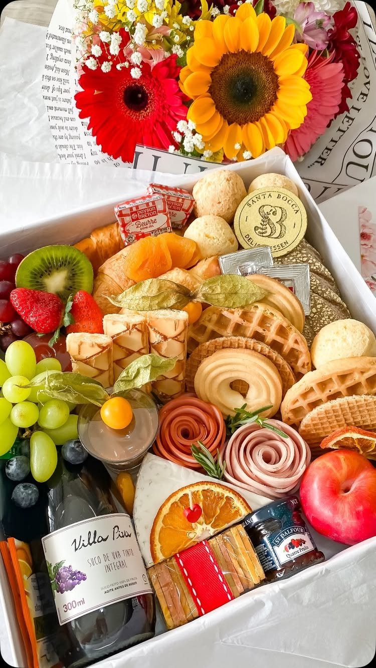 Brunch gift box with waffles, fresh fruit, deli meats, wine, and bright sunflowers.