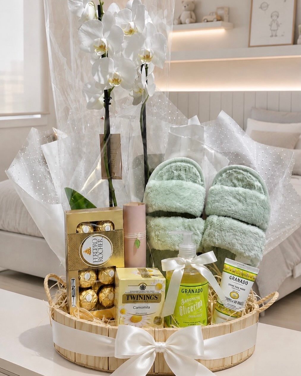 Wicker gift basket with green slippers, white orchids, chocolates, tea, and skincare products.