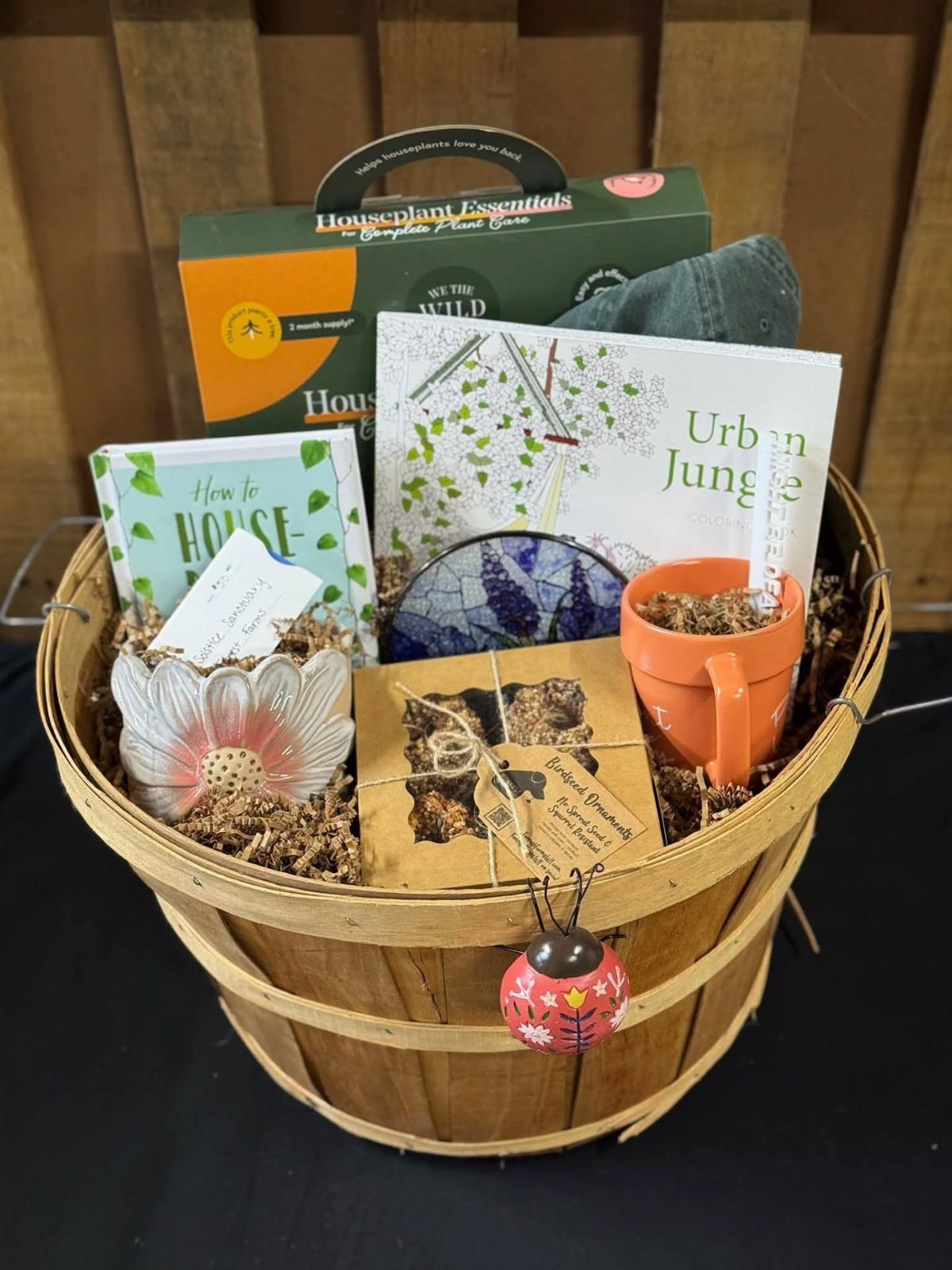 Gardening gift basket with houseplant books, care kit, and orange mug in wooden basket