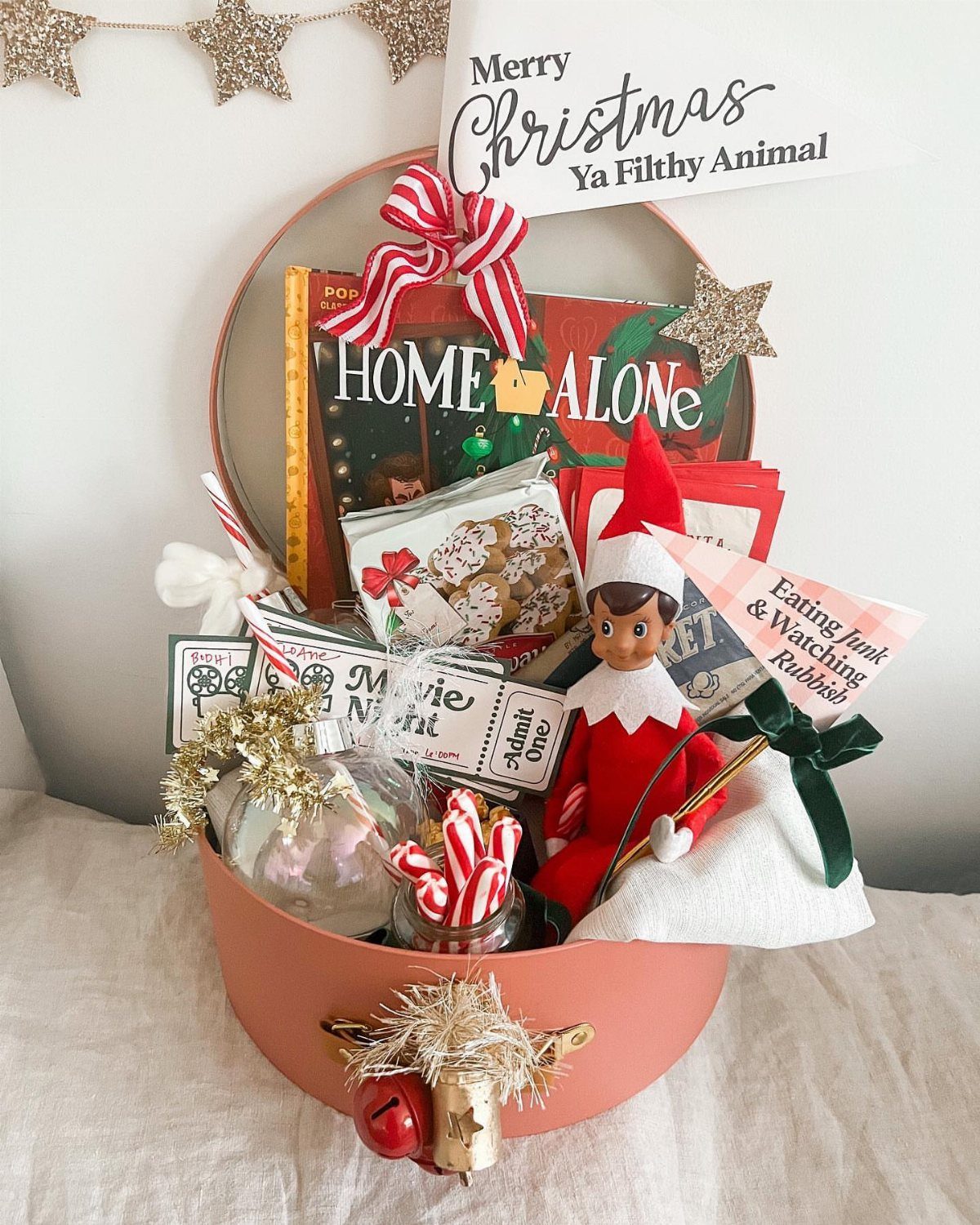 Movie night gift basket with Home Alone DVD, elf doll, and candy canes.