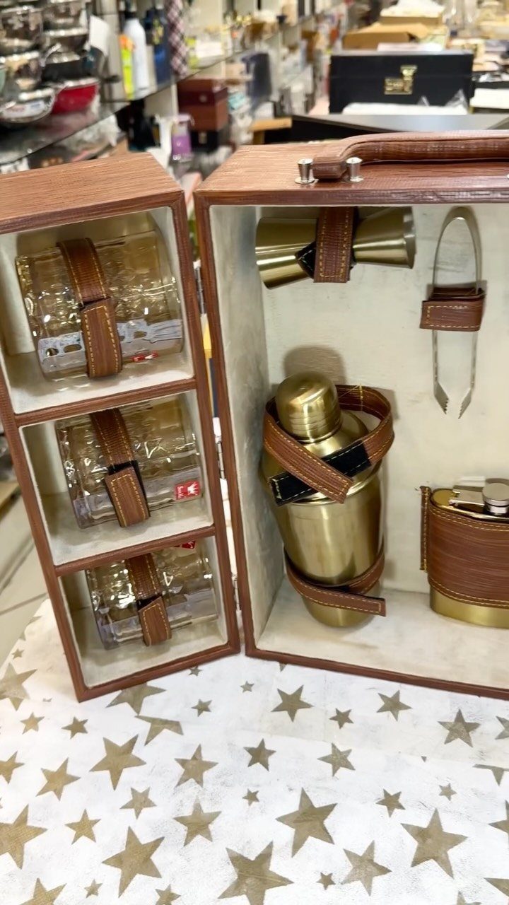 Leather gift set containing a gold flask, metal cup, and three glass tumblers.