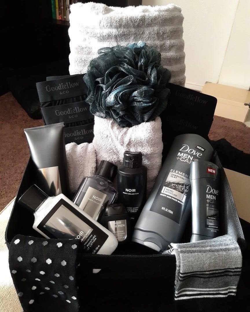 Men's grooming gift box with toiletries, towels, and socks in a black container.