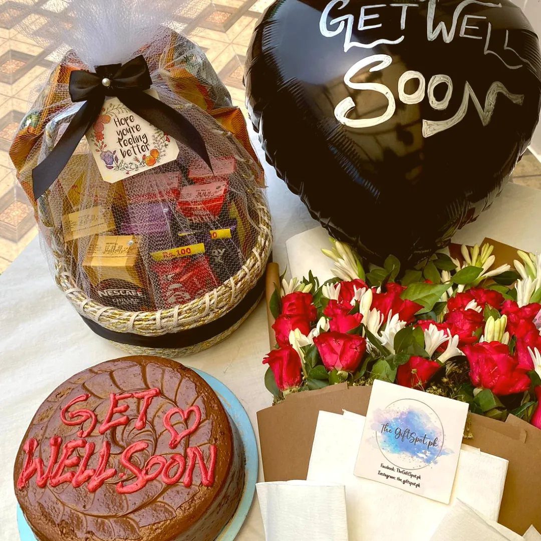 Get well soon gift set with snack basket, heart balloon, cake, and flowers.