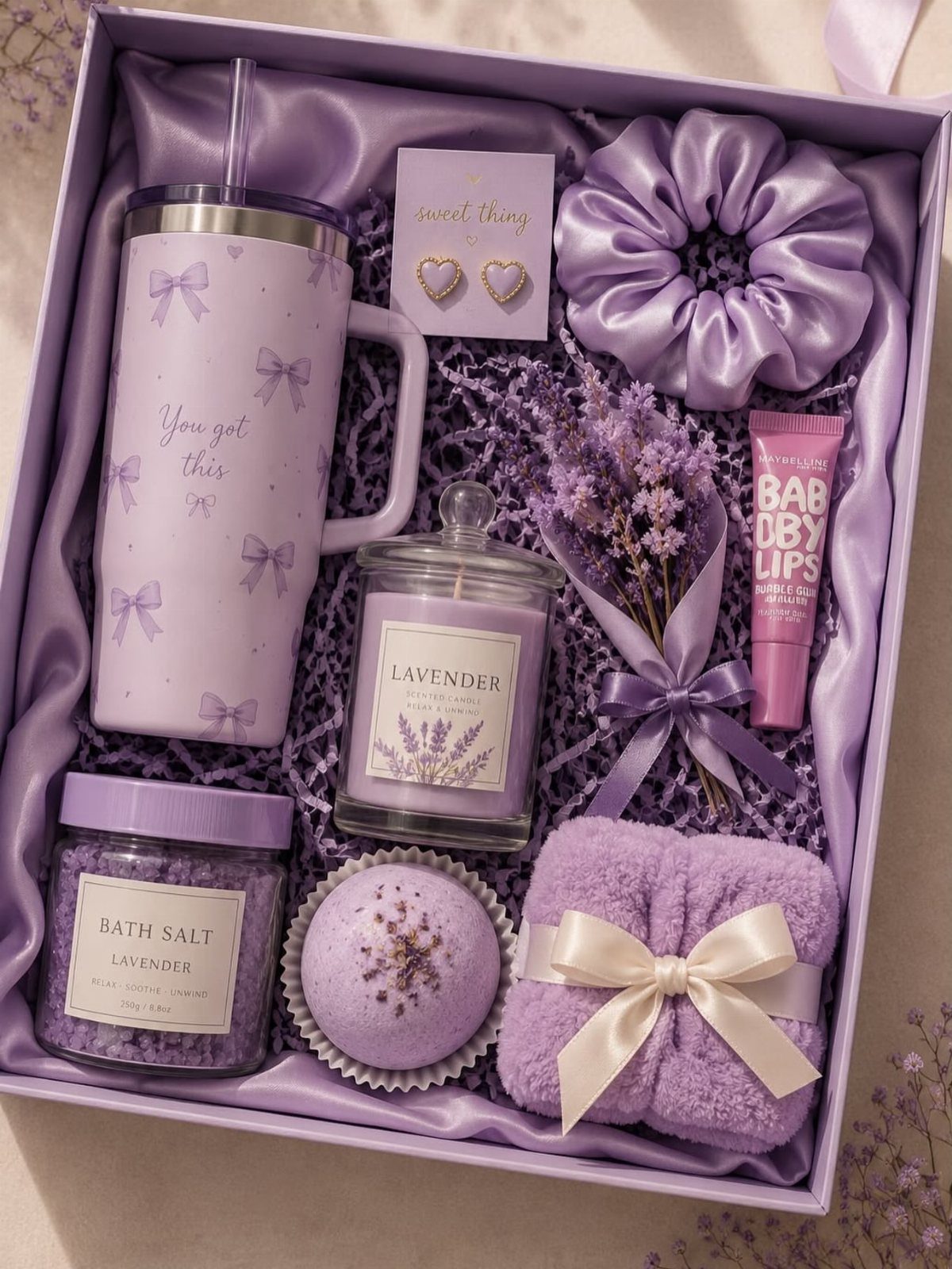 Purple gift hamper containing a tumbler, candle, bath salts, and lavender-themed spa items.
